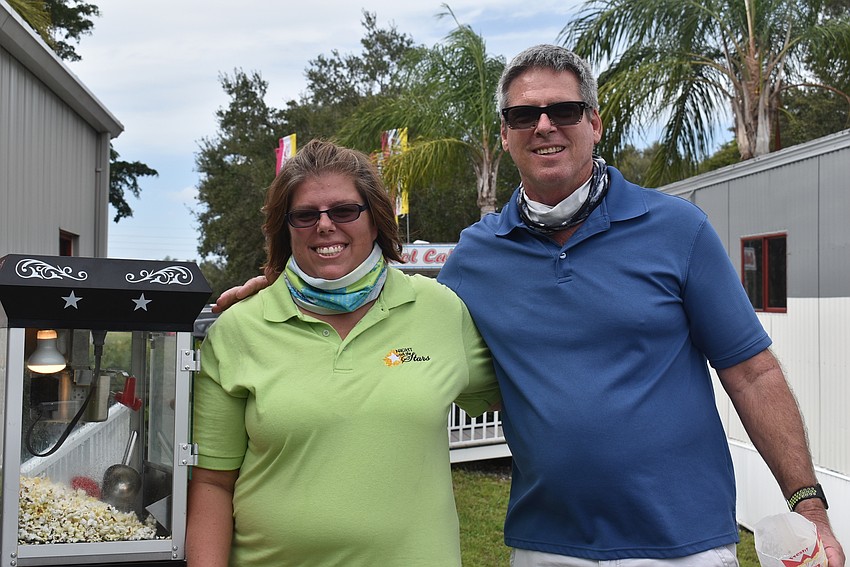 Night with the Stars board member Nicole Washington (left) stands with her father, Jeff Mohler of Palmetto, who came to the craft show to do Christmas shopping.