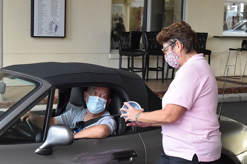 Lakewood Ranch's Terry Gubbins takes a ceramic bowl from Cindy Sloan, the general manager of the Food Bank of Manatee.