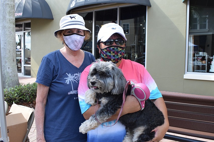 Lakewood Ranch's Nina Williams and Ruby Olegario and her dog, Dori, make a donation to Meals on Wheels Plus of Manatee after seeing the line of cars for Empty Bowls while enjoying lunch on Main Street at Lakewood RAnch.