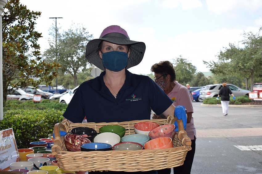 Amy Towery, the vice president of development for Meals on Wheels Plus of Manatee, showcases some of the bowls as people come through the drive-thru.