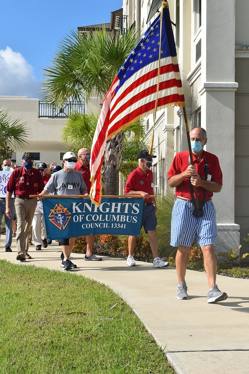 Knights of Columbus member Richard Kuebel (holding American flag) leads the parade around The Sheridan at Lakewood Ranch assisted living facility.