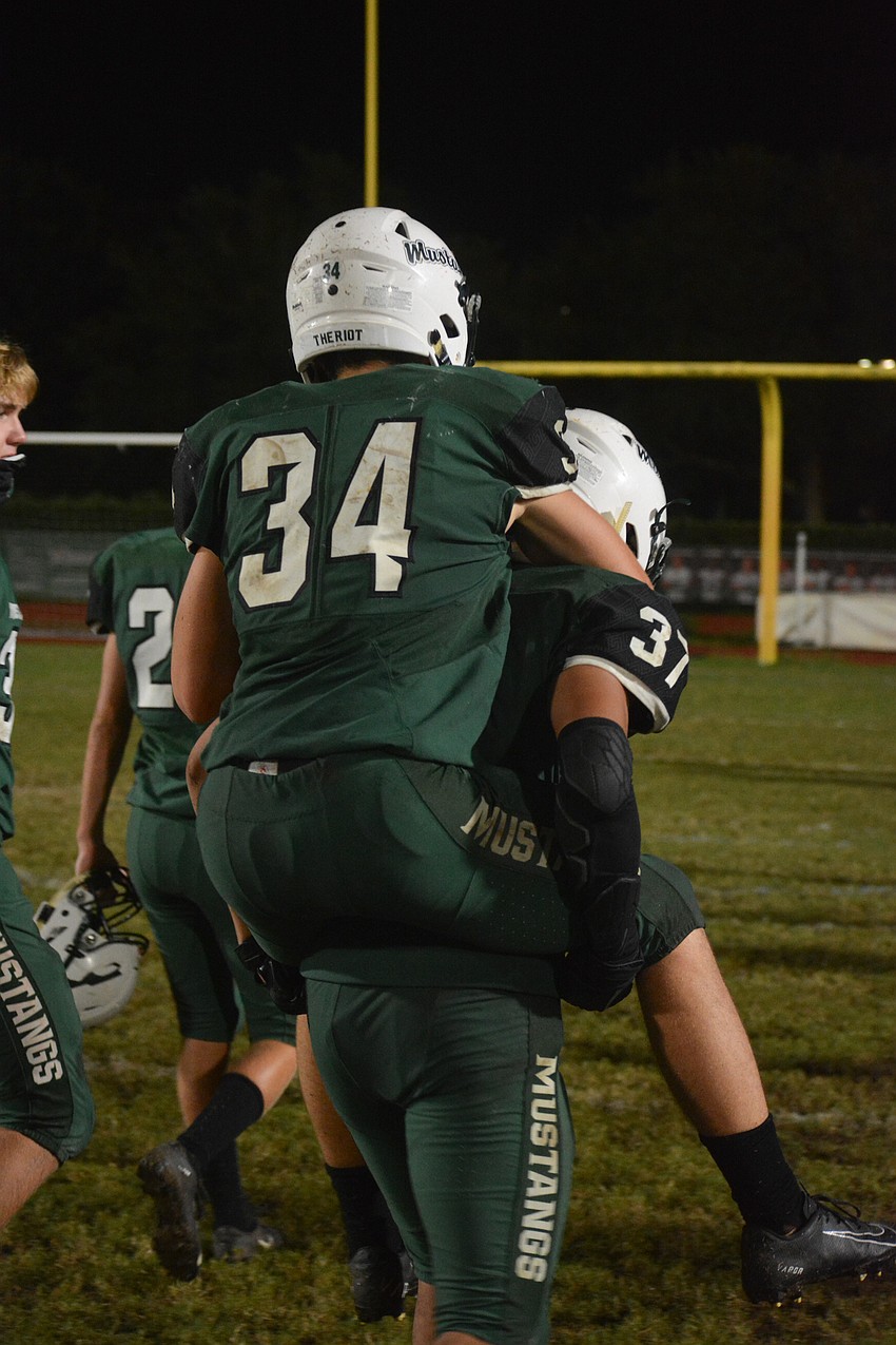 Lakewood Ranch senior linebacker Brody Theriot (34) is carried off the field on the shoulders of junior linebacker Neale Ngov.