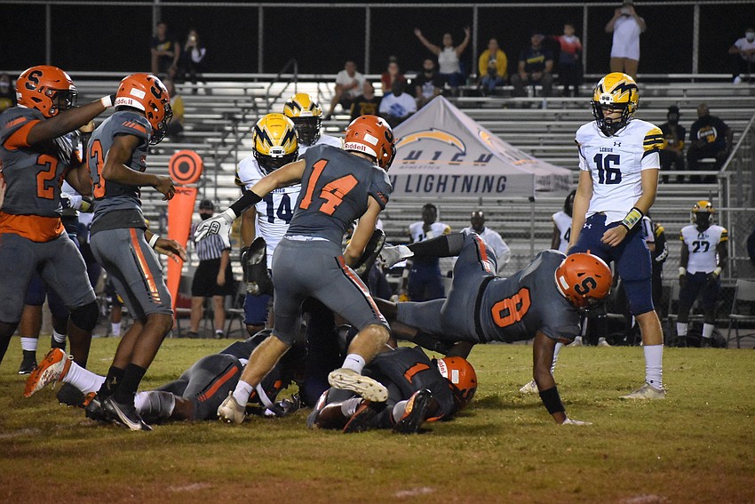 Sarasota Sailors defenders rally to the football to complete a tackle.