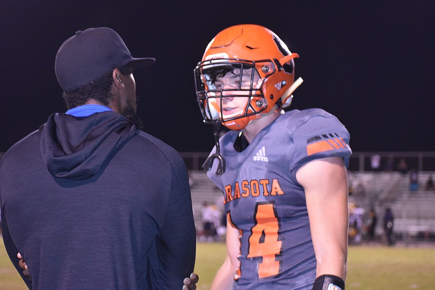 Sarasota junior Ashton Turner (right) talks with defensive backs coach Jonathan Pitts after the Sailors' defense gave up its second touchdown of the first half to fall behind 14-0.