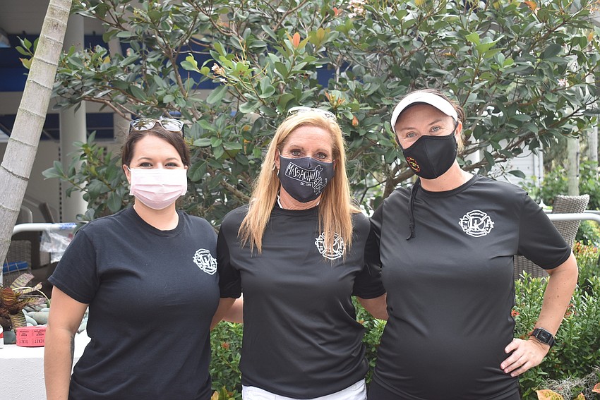 Mishel Franklin, Lisa Apicelli and Missina Cutting run the sign-in table and auctions.
