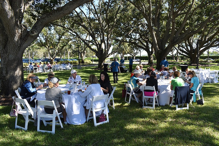The golfers ate under the mottled shade of the Longboat Key Club's oak trees.