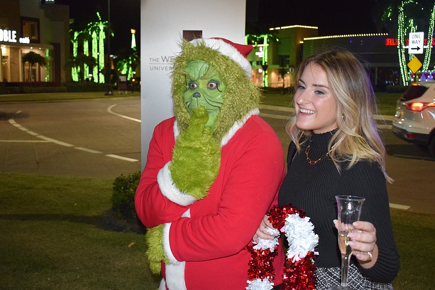 The Grinch, played by Chris Cude of Legendary Knights Entertainment of Winter Haven, checks out the holiday lights with Sarasota's Melissa Galmin.