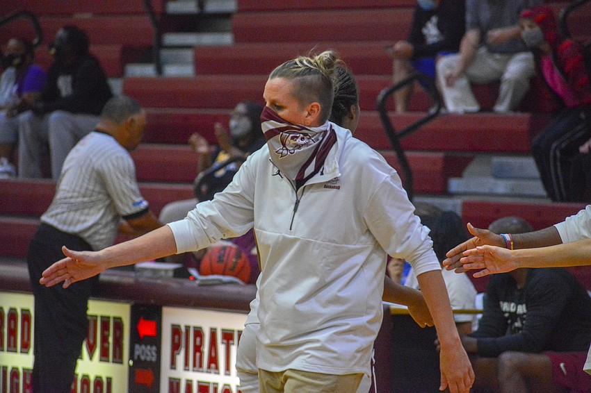 Pirates Coach Stephanie Smith gives her team high fives for its effort against Montverde Academy.