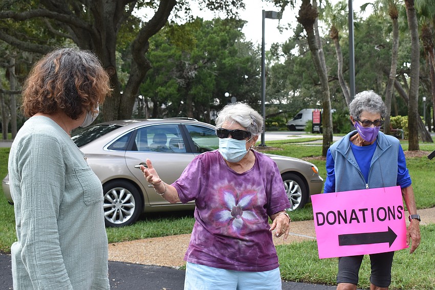 Karen Gary chats with Debby Hamburg as Max Spitzer unloads Hamburg's donations.