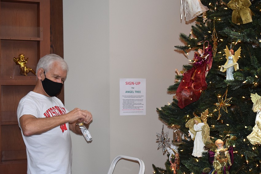 Steve Whalen prepares to hang angels on a tree.