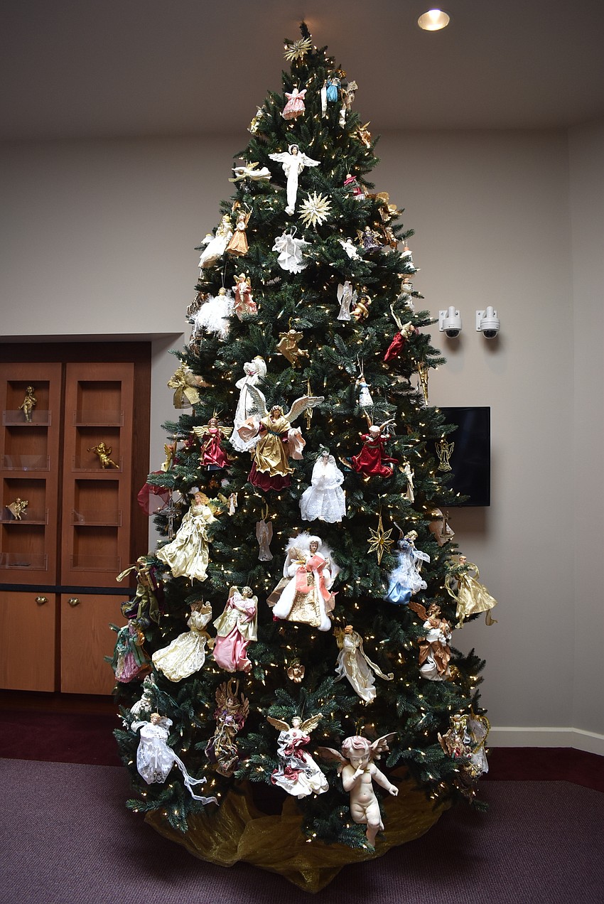 A finished tree is decorated entirely with angels.