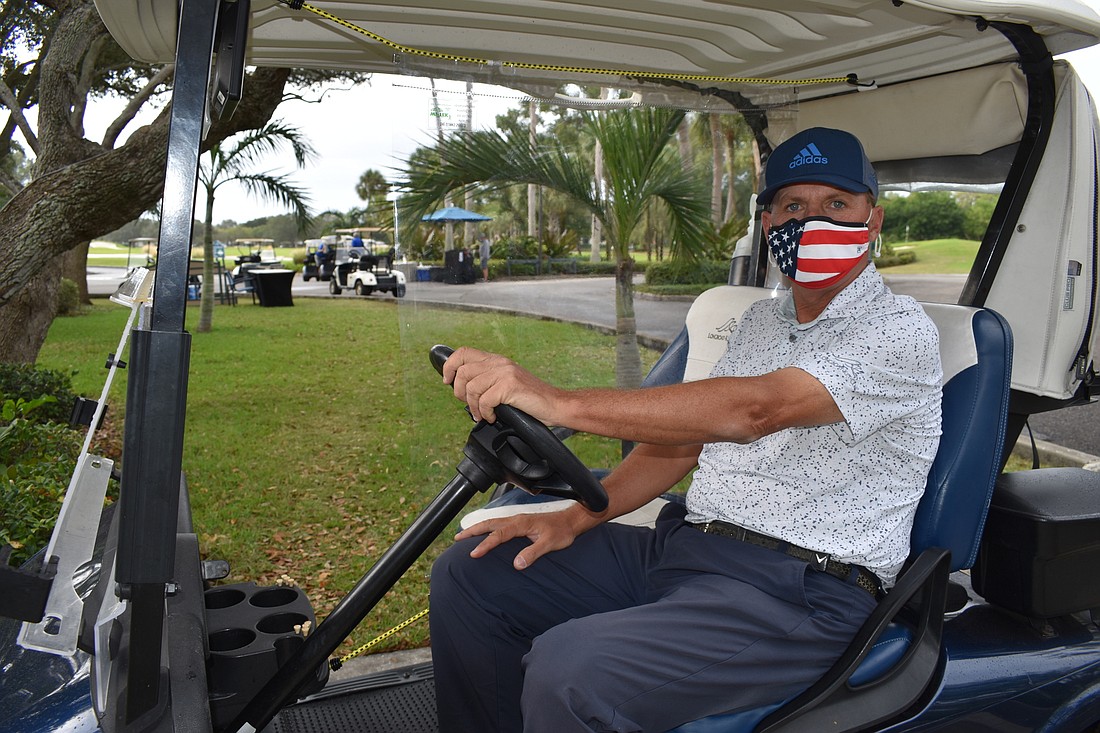 Longboat Key Club golf director Terry Oâ€™Hara sits in a golf cart with a plastic divider installed to provide separation between the driver and a passenger.