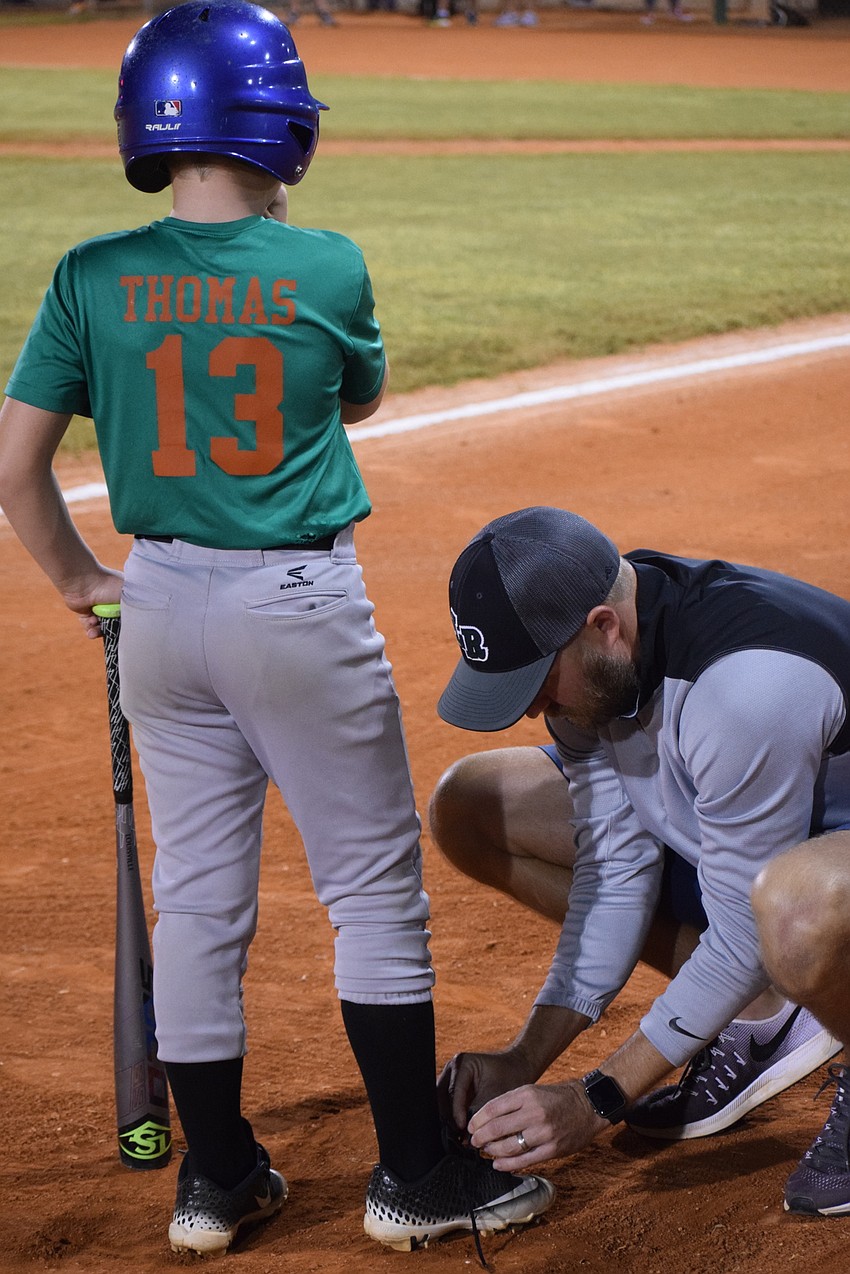 Coach Eddy Thomas takes care on an unexpected task for his son, Eddy.