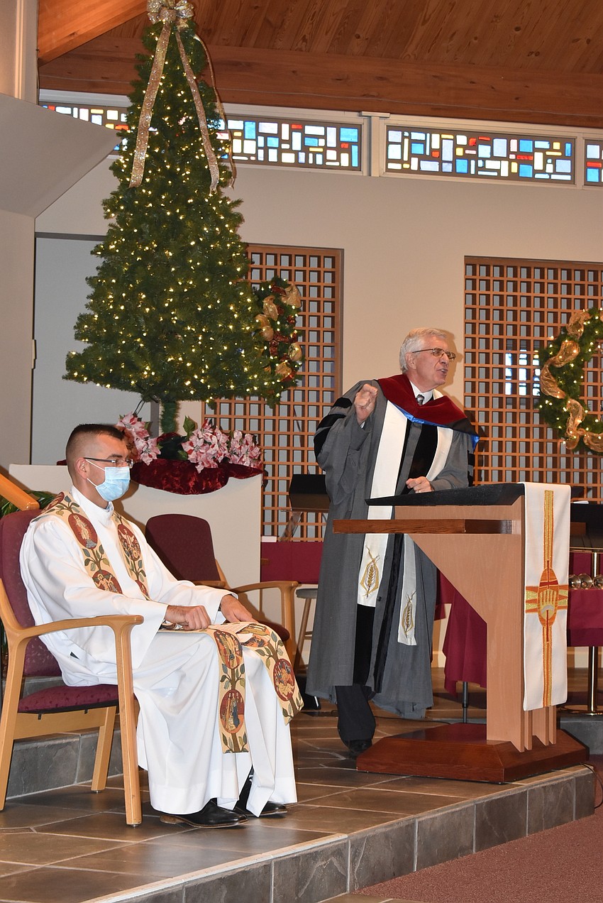 Father Robert Dziedziak sits while the Rev. Norman Pritchard speaks.