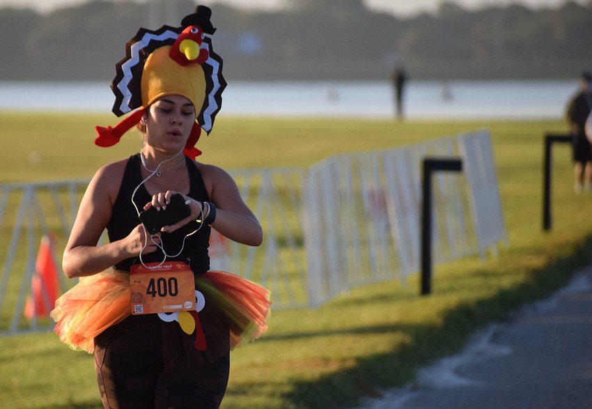 Sarasota's Isabella Williamson checks her finishing time. She says she needed to get a workout before she starts eating turkey.