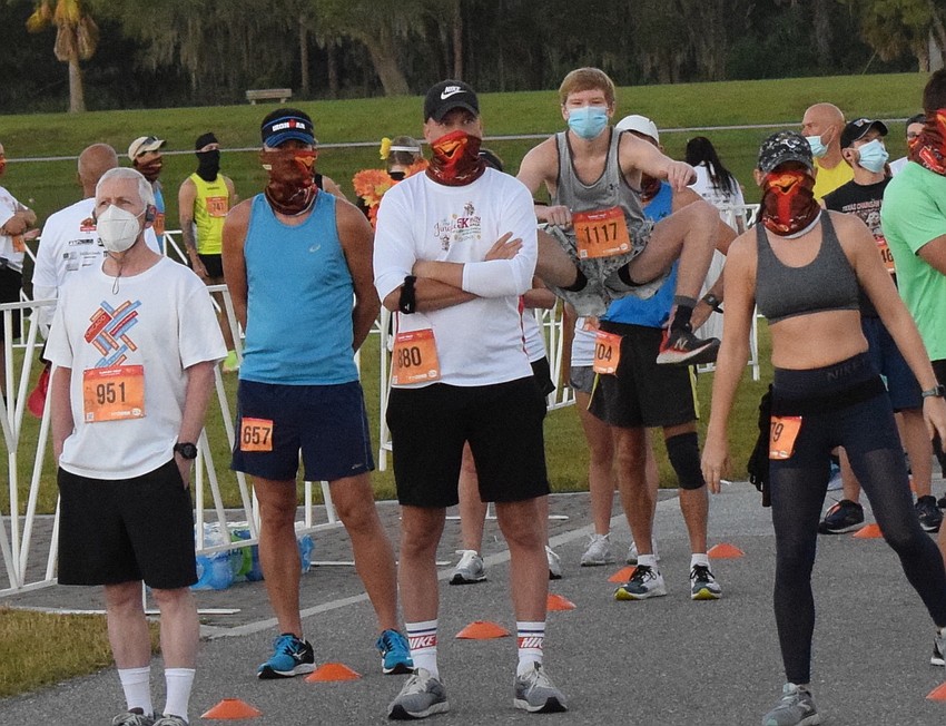 Griffin McNeish of Summerville, S.C. (jumping) appears a little more serious about his warm-up than other Turkey Trot runners around him.