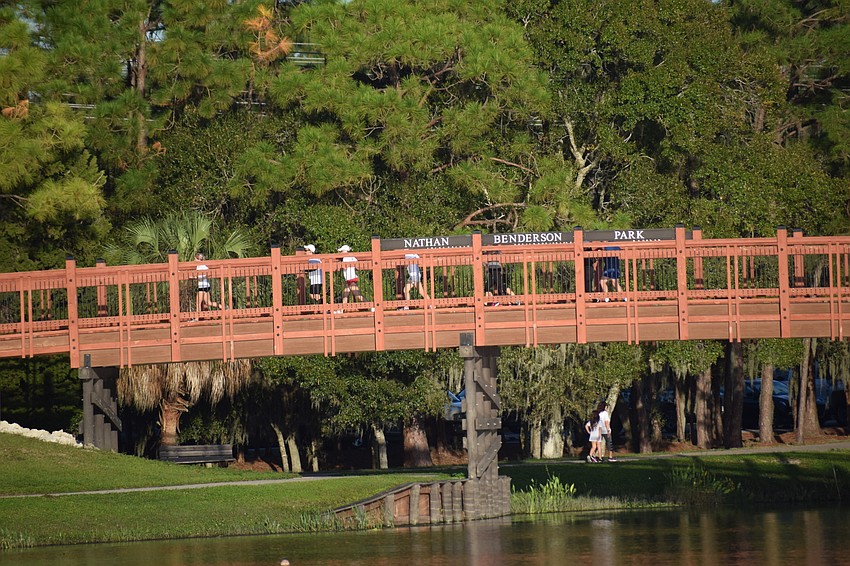 Runners enjoy the scenery as they cross a bridge at Nathan Benderson Park.