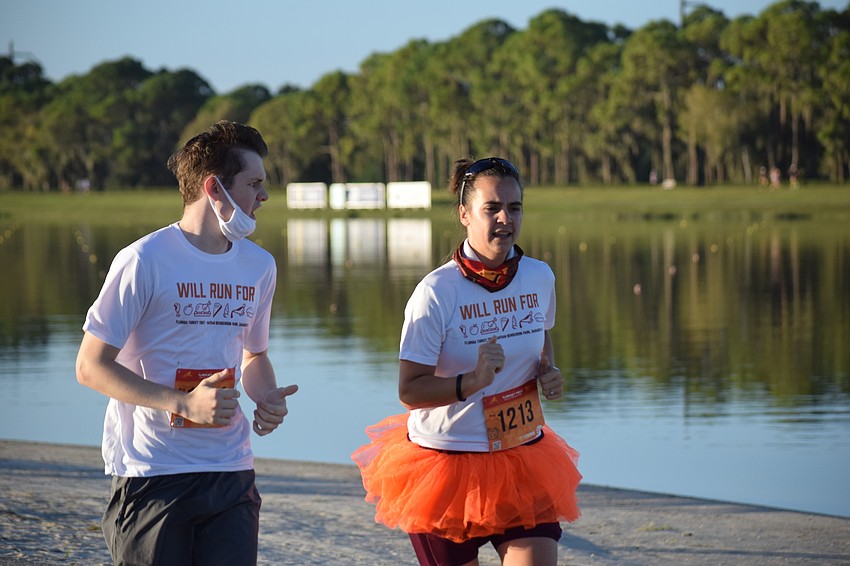 Friends Ethan McCormack of East County and Alexa Olivas of Bradenton finish alongside the lake.