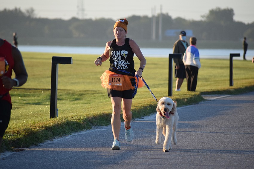 Venice's Karen Bray and her Goldendoodle Newton finish. She says the race allows her to eat a little more turkey than planned.