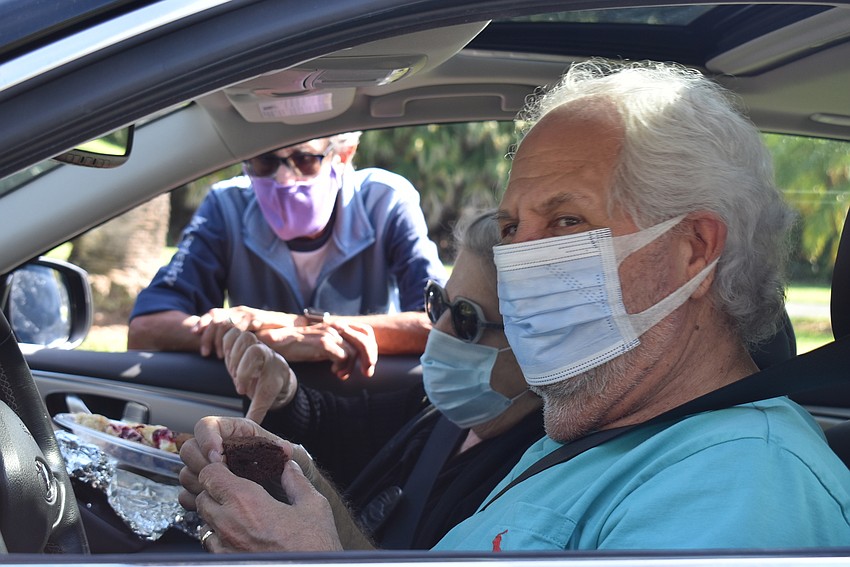 Mac Spitzer hands a tray of treats to Sylvia and Irwin Pastor.