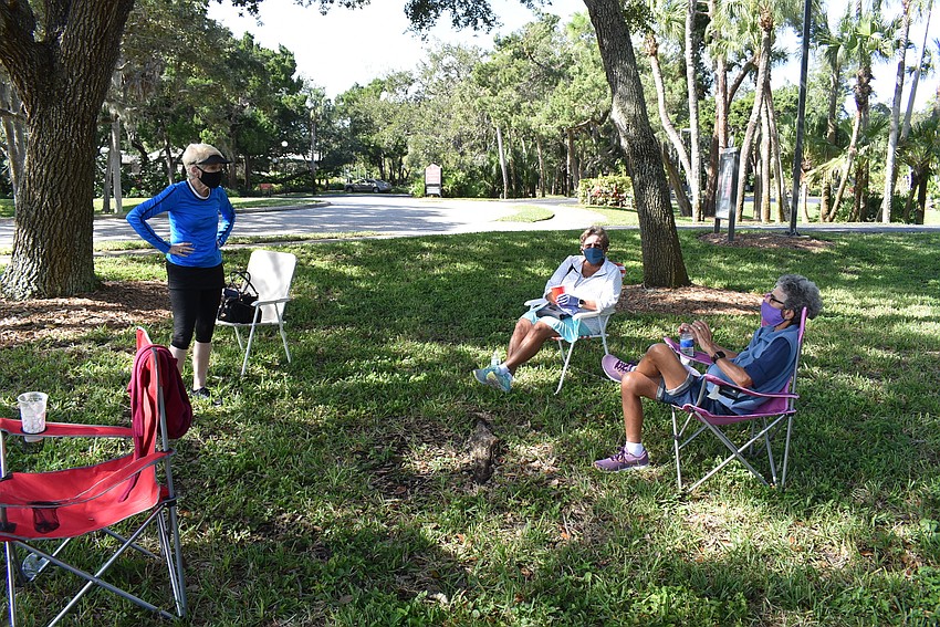 Bonnie Wilder, Judy Tobias and Mac Spitzer catch up in the shade.
