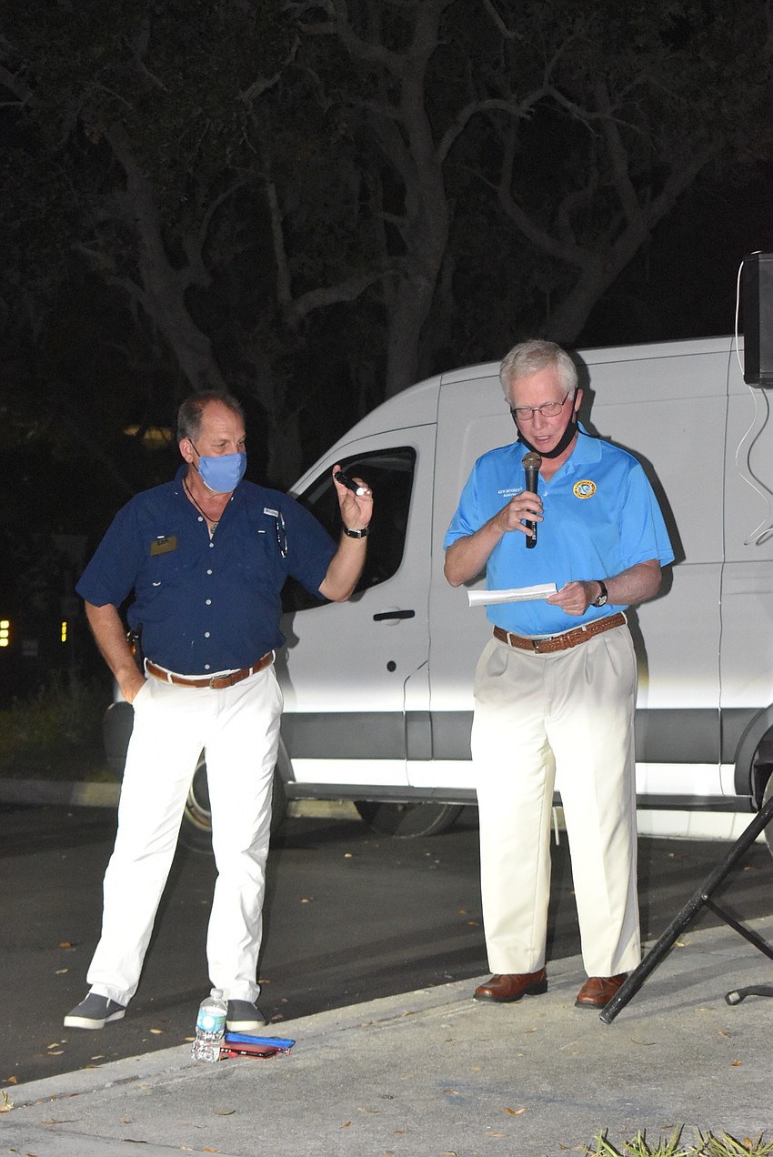 Mark Meador provides light for Mayor Ken Schneier.