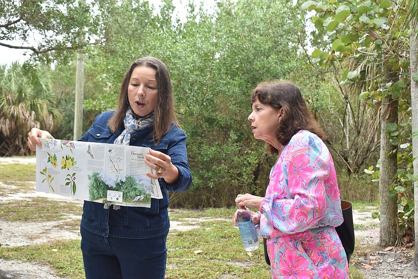 At an intersection of the park's winding paths, Zelia Trueb and Kathryn Carr check where they are.