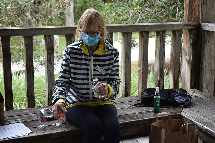 Linda Ulrich pours water into her Longboat Key Garden Club wine glass.