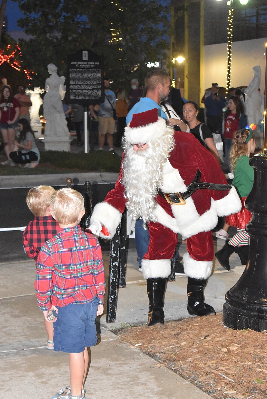 Nicholas and Alexander Couturiaux high-five Santa Claus.
