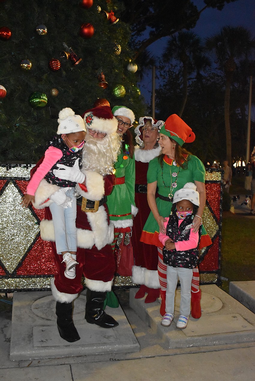 Niavy and Janeli Griffith flag down Santa Claus and his elves just before the tree lighting.
