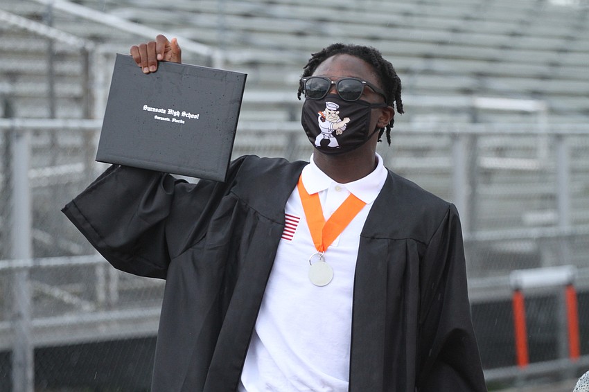 July 23: Malik Bryant holds up his diploma from Sarasota High School.