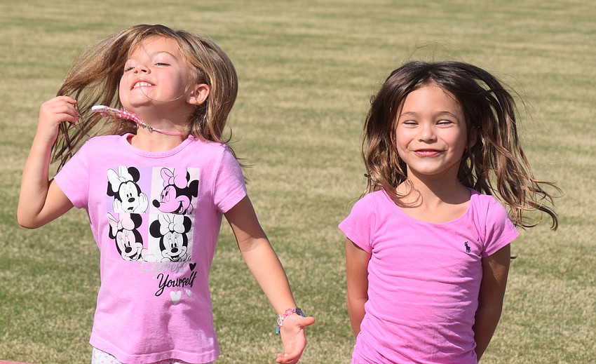 Lake Club's Amilia Dragovoy, 4, and Mya Medford, 5, are neighbors who enjoy a little dance on the polo field before the game.