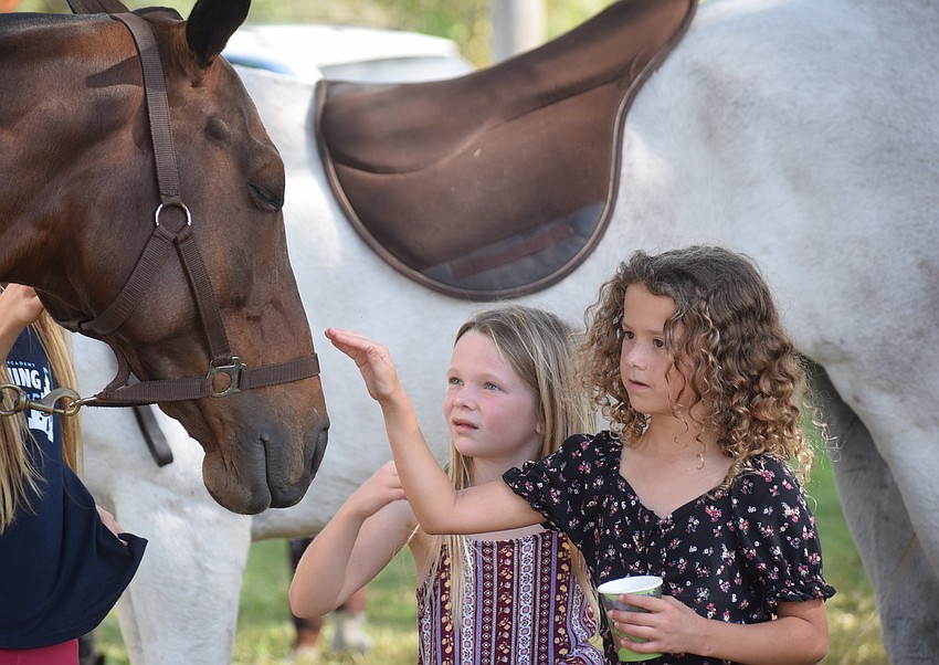 Lakewood Ranch's Lily Hirons, 7, and Madison Rivera, 6, get up close and personal with a polo horse before the match.