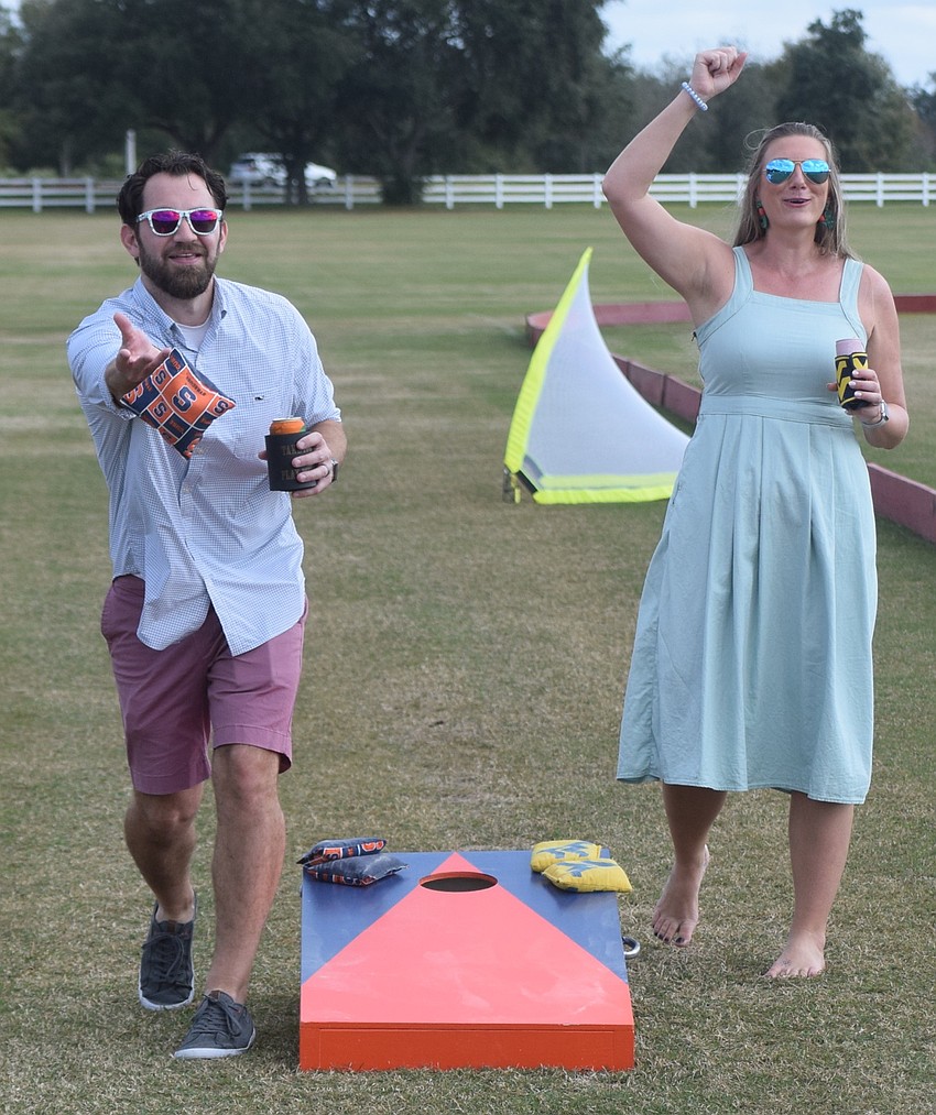 Lakewood Ranch's Justin Miano takes dead aim during a game of corn hole while his wife Elizabeth Miano offers him some support.