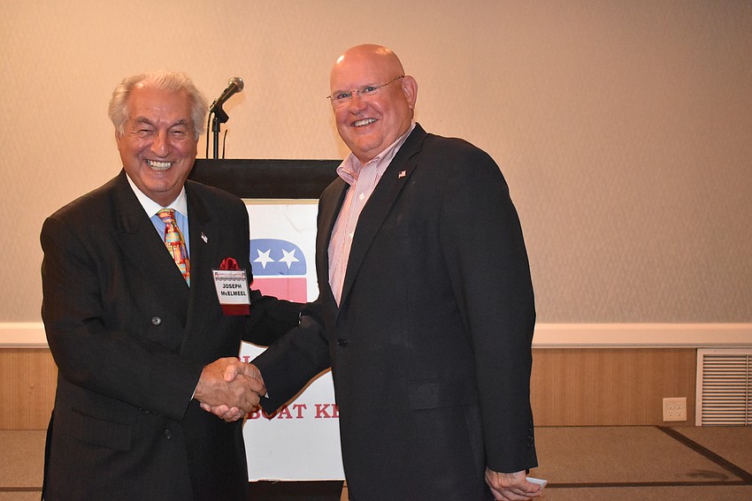 Outgoing president Joe McElmeel shakes hands with incoming president Scott Gray.