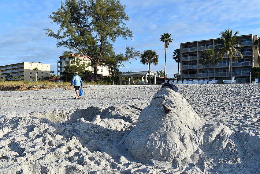A sand-man with a discarded hat.