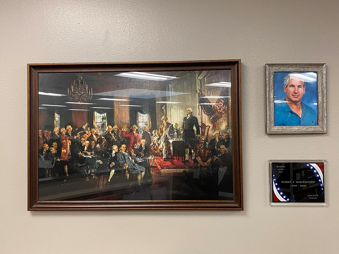 A memorial featuring a plaque, a portrait of Shackelford and his favorite painting hangs in the school&#39;s media center. Photo courtesy