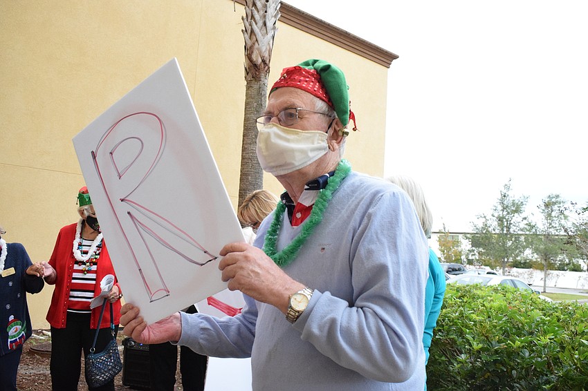 Jim Beeresford holds up a sign with the letter 