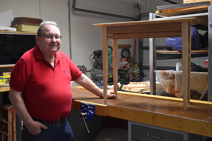 Whisper Bend resident Alan Brown, who considers himself a jack of all trades and master of none, stands by a contemporary hall table he made out of ash and maple woods.