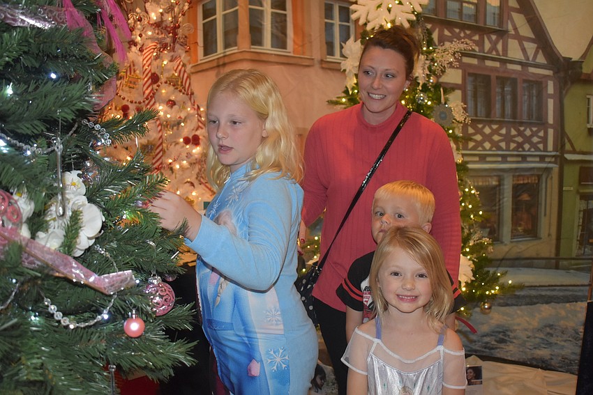 Jane, Jessica, Jack and Juliett Coay of Palm Aire admire the tree created by In the Pink, a boutique for women living with cancer. It was Jane's favorite tree because of the peacock feathers and pink and white color coordination.