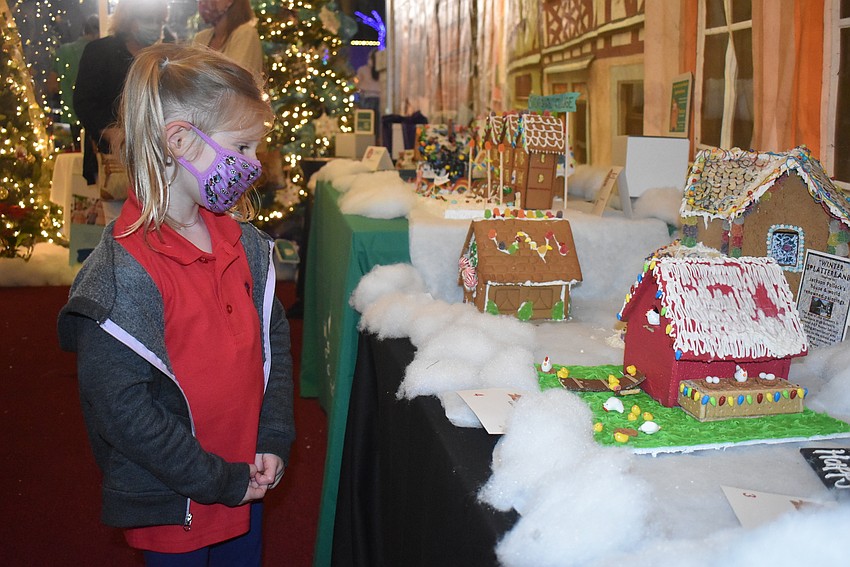 4-year-old Avery Hull from Parrish likes this gingerbread house, made by Lakewood Ranch-based law firm Luhrsen Goldberg, because of the chickens.