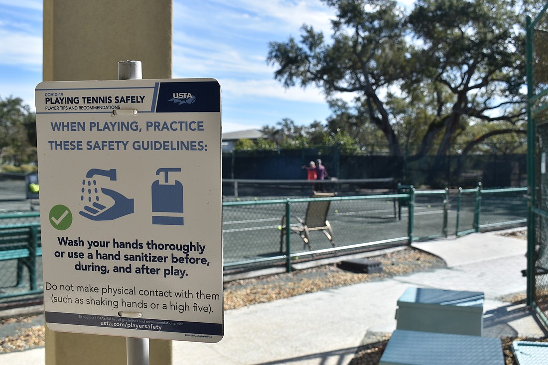 Signs at the Longboat Key Public Tennis Center remind players to keep their distance on and off the courts.