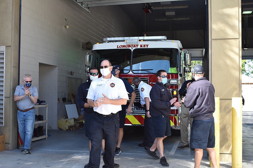 Longboat Key Fire Rescue personnel and town staff push the new fire truck into the bay at 5490 Gulf of Mexico Drive.