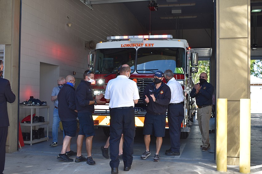 Longboat Key Fire Rescue personnel and town staff push the new fire truck into the bay at 5490 Gulf of Mexico Drive.