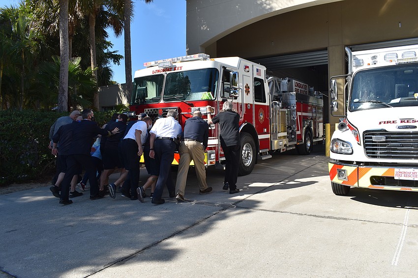 Longboat Key Fire Rescue personnel and town staff push the new fire truck into the bay at 5490 Gulf of Mexico Drive.