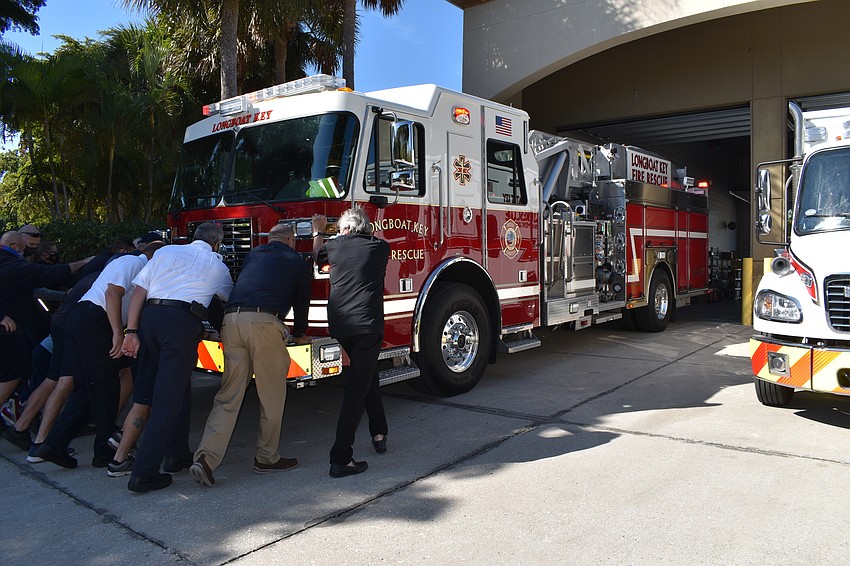 Longboat Key Fire Rescue personnel and town staff push the new fire truck into the bay at 5490 Gulf of Mexico Drive.