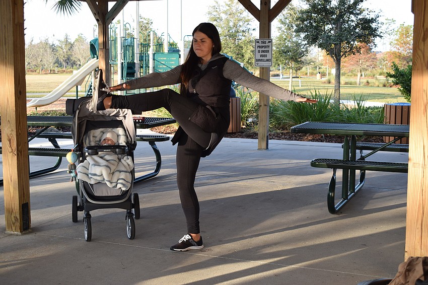 Arbor Grande's Victoria Korotkova exercises while her 3-month-old son, Ian Korotkov, watches from his stroller.