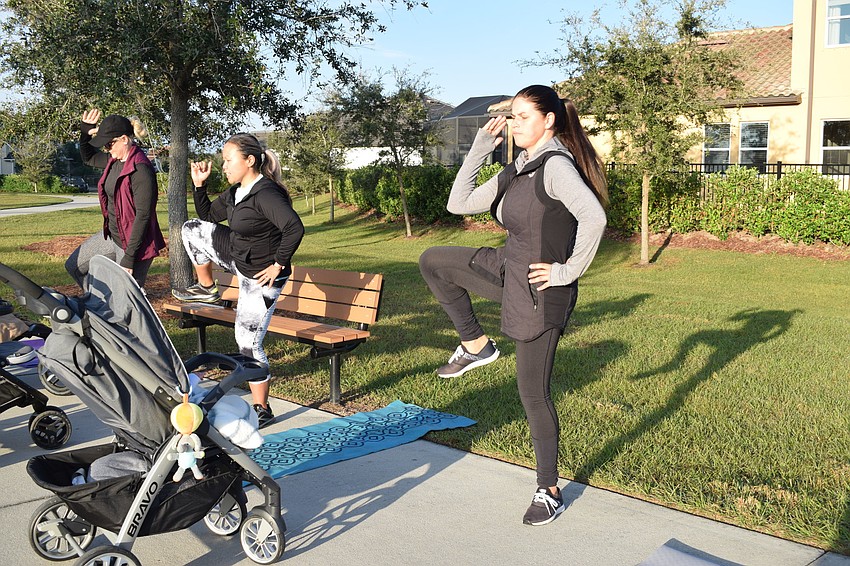 RaeAnna Kalkert, Marie Tabuena-Urriola and Victoria Korotkova do side crunches after taking three minutes to fast walk with their strollers.