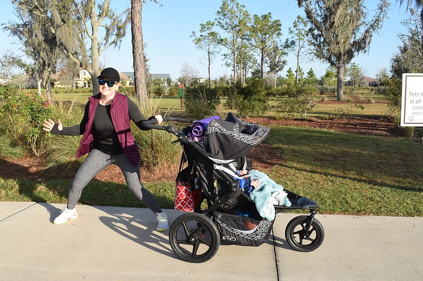 Esplanade's RaeAnna Kalkert shuffles along the pathway as she pushes her 18-month-old children Hudson and Dakota Kalkert in their stroller.