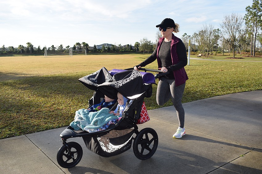 Esplanade's RaeAnna Kalkert does butt kicks while pushing her stroller. Kalkert joined the class to be able to socialize with other mothers while being able to exercise.
